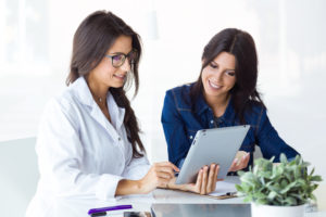 Female doctor and her patient discussing treatment options with an iPad.