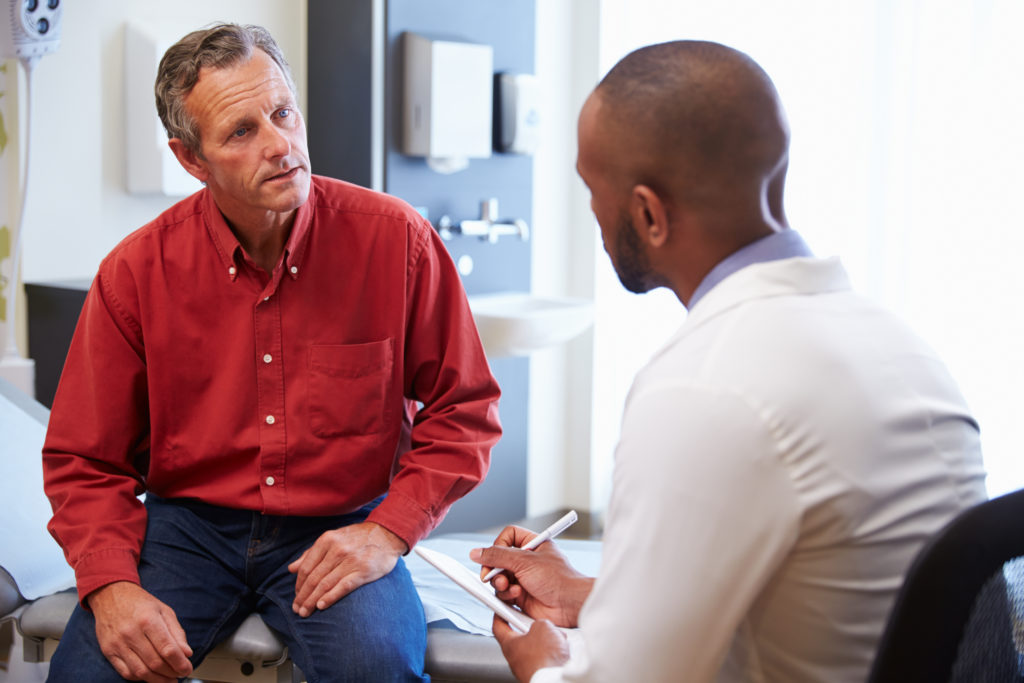 Man discussing medical treatment with his doctor.