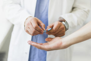 Doctor giving patient pills from a blister package.